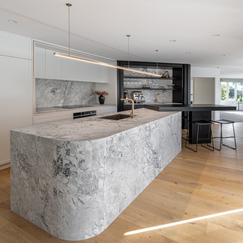 Super white multi faceted cruved waterfall kitchen island and kitchen 1 v3