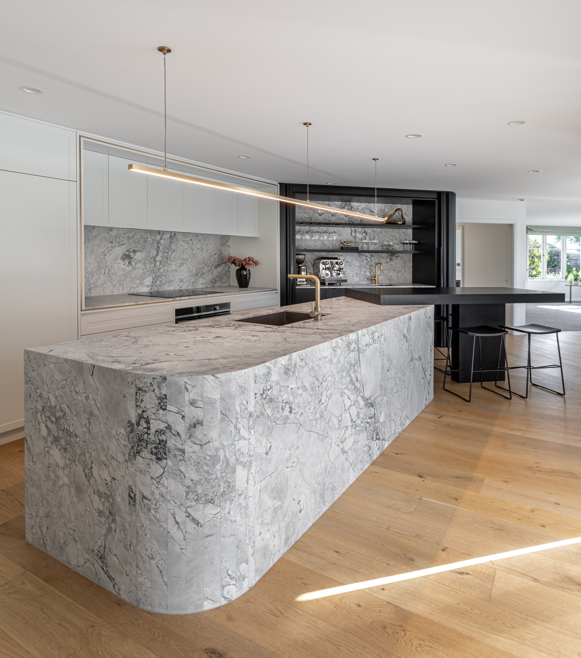 Super white multi faceted cruved waterfall kitchen island and kitchen 1 v3
