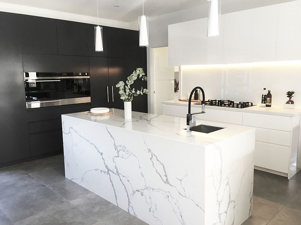 Modern kitchen in black and white with marble island and concrete floor