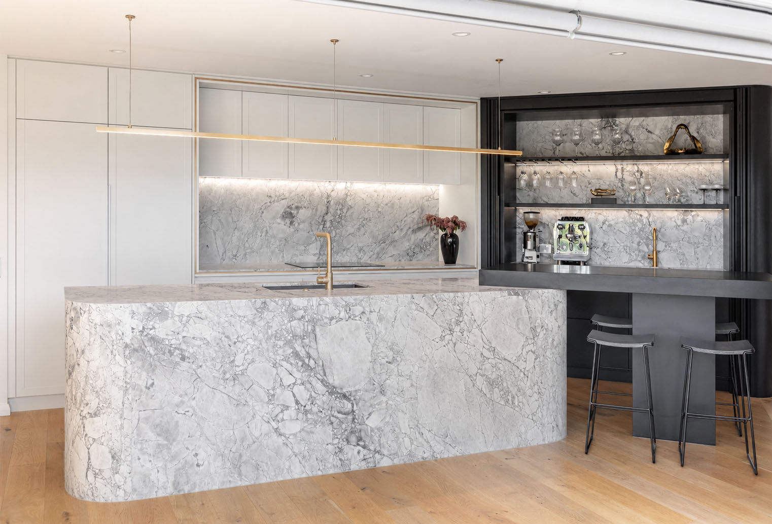 Superwhite Dolomite kitchen island with fluted waterfall ends and splashbacks and rear benchtop